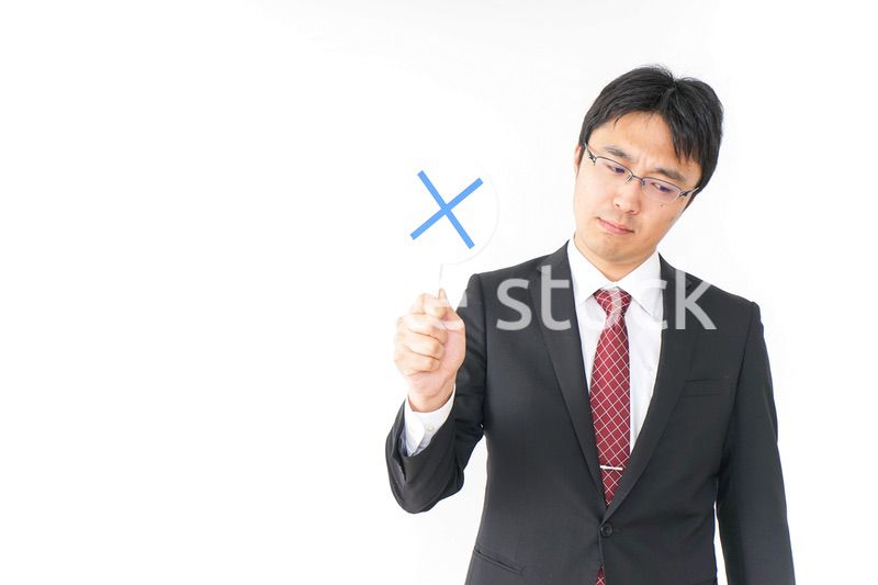 バツ印を示すビジネスマン