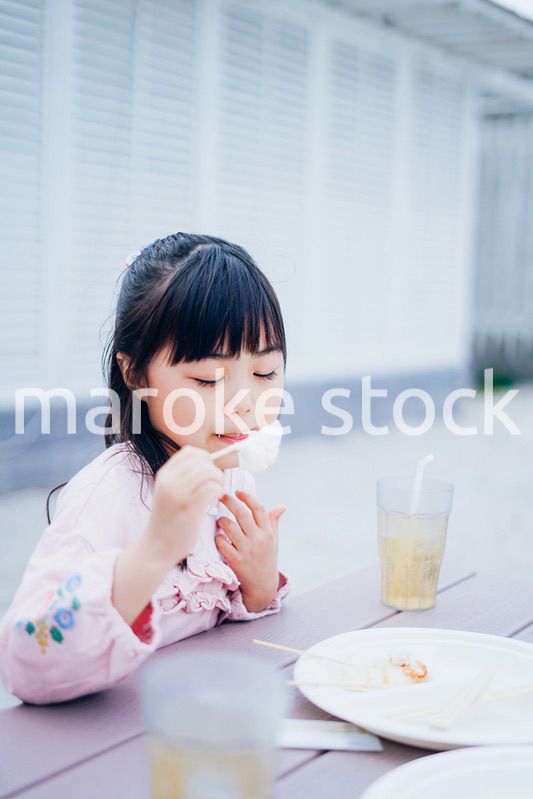外でご飯を食べる小さな女の子