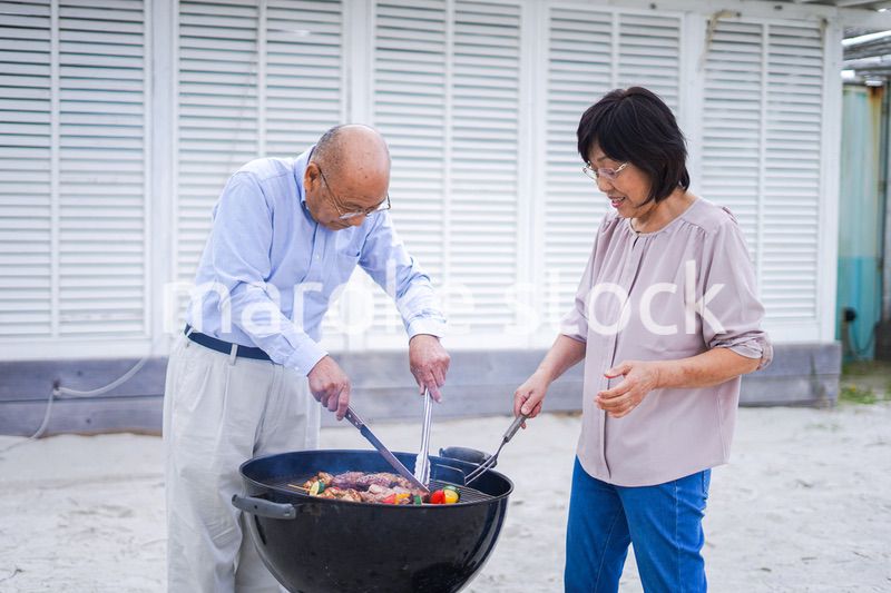 屋外でバーベキューをするアクティブシニア