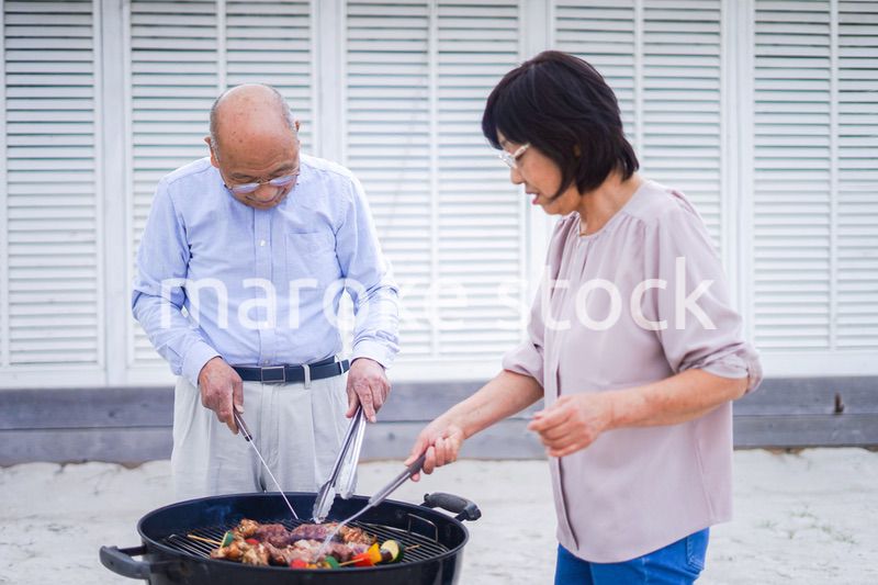 屋外でバーベキューをするアクティブシニア