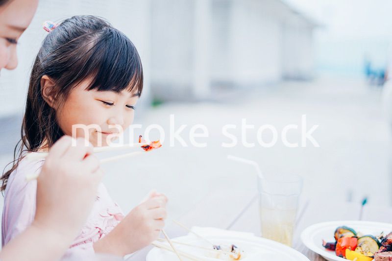 外でご飯を食べる小さな女の子