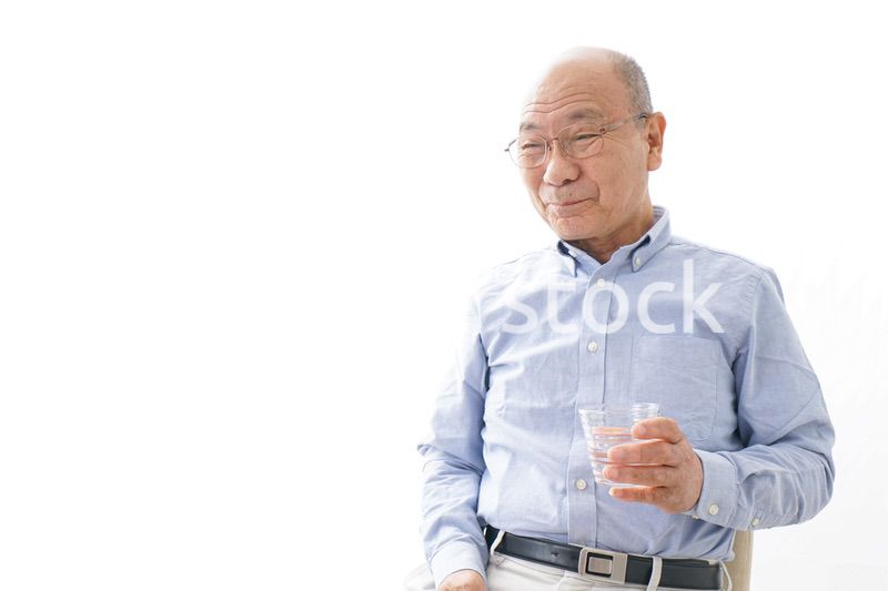 薬を飲む高齢男性