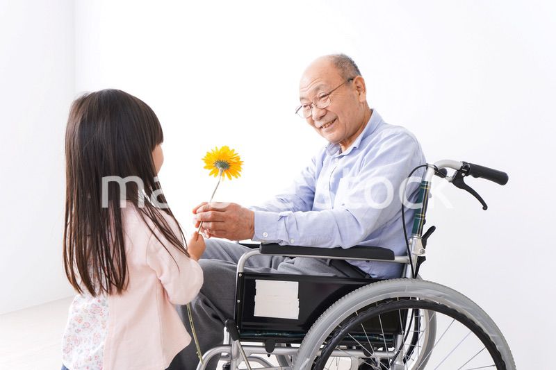 おじいちゃんにお花を渡す女の子