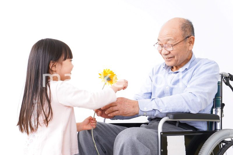 おじいちゃんにお花を渡す女の子