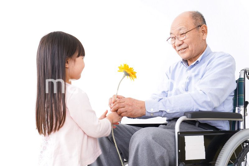 おじいちゃんにお花を渡す女の子