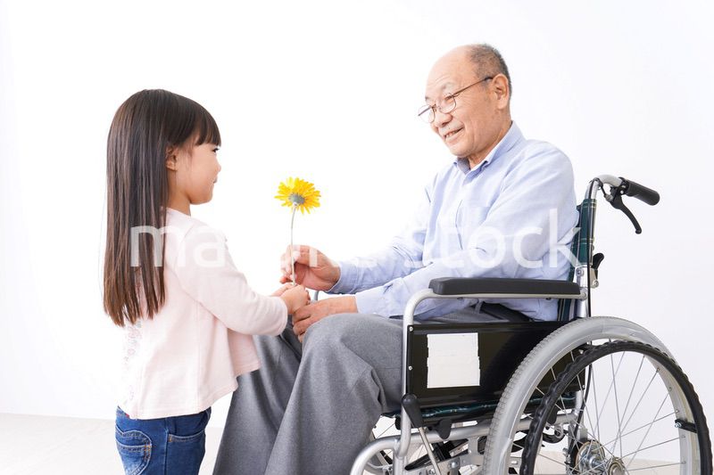 おじいちゃんにお花を渡す女の子