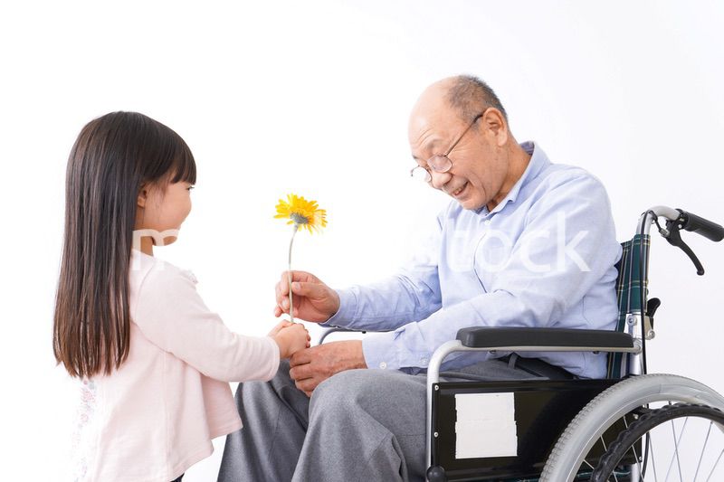 おじいちゃんにお花を渡す女の子