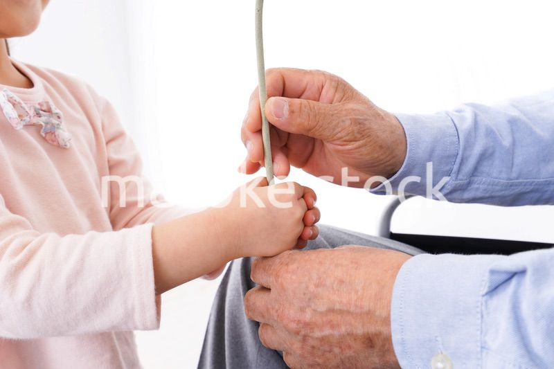 おじいちゃんにお花を渡す女の子