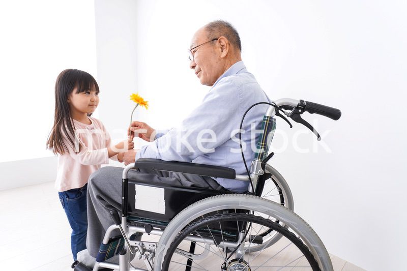 おじいちゃんにお花を渡す女の子