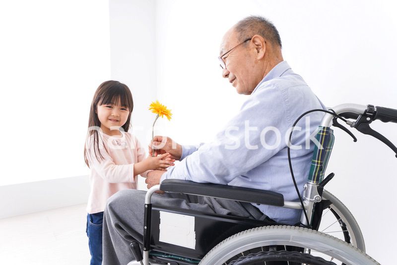 おじいちゃんにお花を渡す女の子