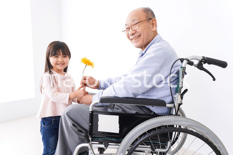 おじいちゃんにお花を渡す女の子