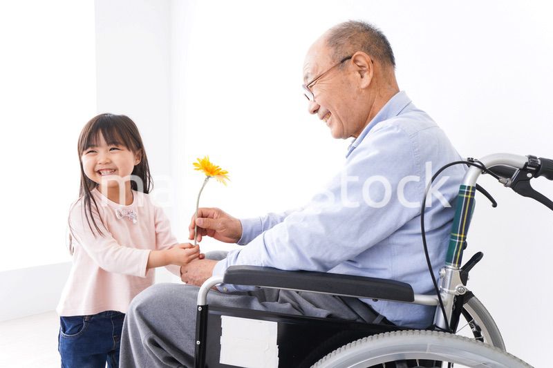 おじいちゃんにお花を渡す女の子