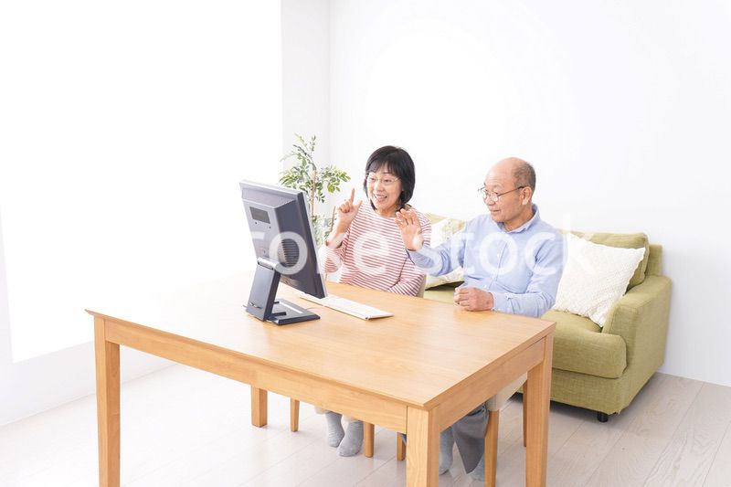 パソコンでテレビ電話をする高齢の夫婦