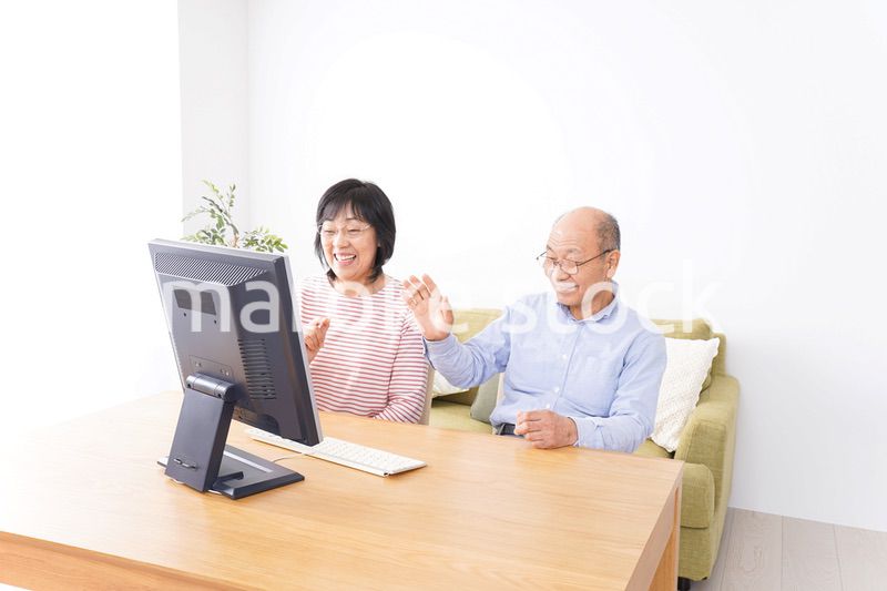 パソコンでテレビ電話をする高齢の夫婦
