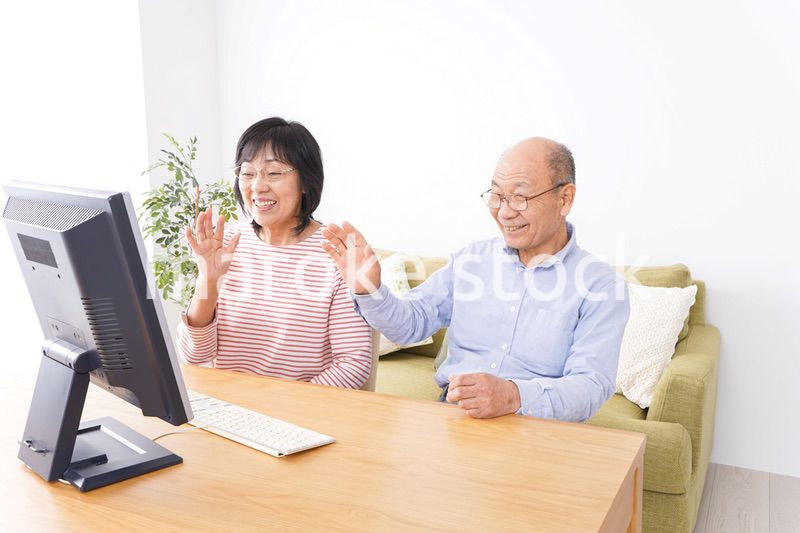 パソコンでテレビ電話をする高齢の夫婦