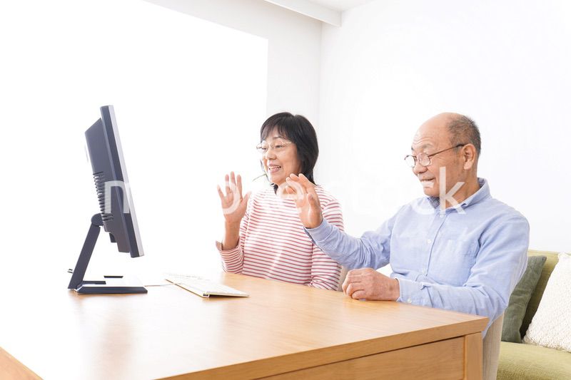 パソコンでテレビ電話をする高齢の夫婦