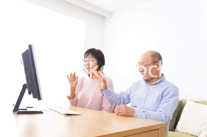 パソコンでテレビ電話をする高齢の夫婦