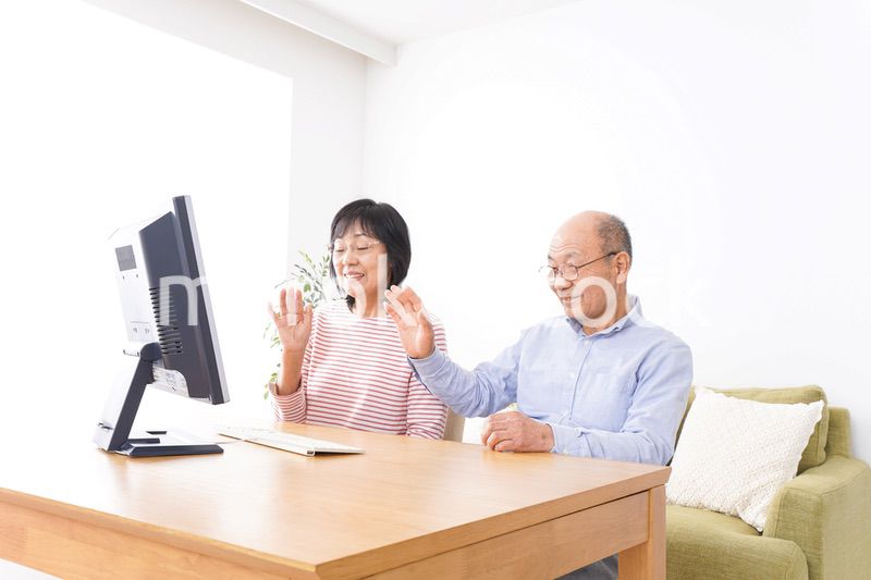 パソコンでテレビ電話をする高齢の夫婦