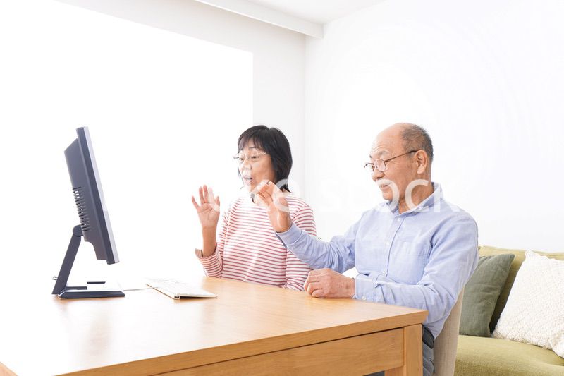 パソコンでテレビ電話をする高齢の夫婦