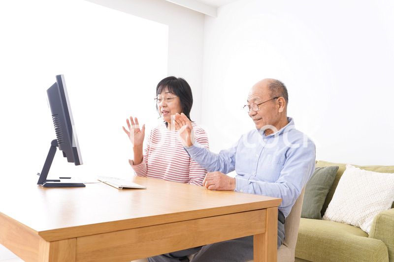 パソコンでテレビ電話をする高齢の夫婦