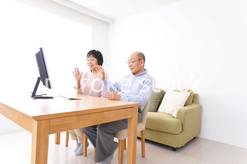 パソコンでテレビ電話をする高齢の夫婦