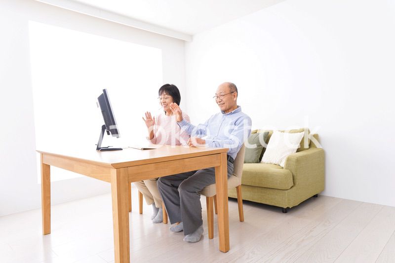 パソコンでテレビ電話をする高齢の夫婦