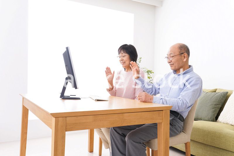 パソコンでテレビ電話をする高齢の夫婦