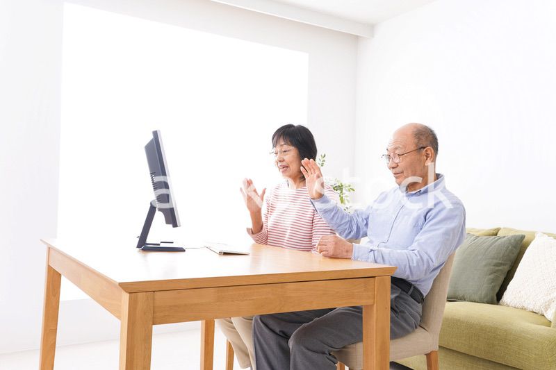 パソコンでテレビ電話をする高齢の夫婦