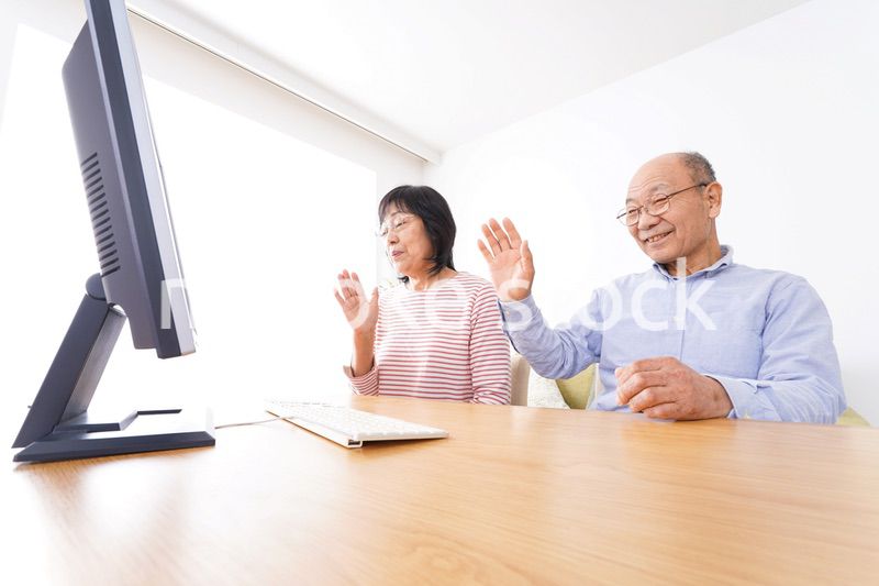 パソコンでテレビ電話をする高齢の夫婦