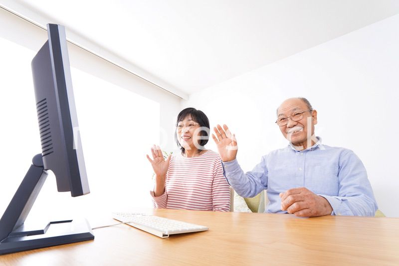 パソコンでテレビ電話をする高齢の夫婦