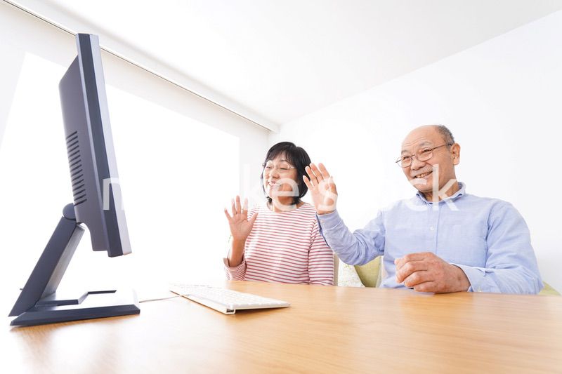 パソコンでテレビ電話をする高齢の夫婦