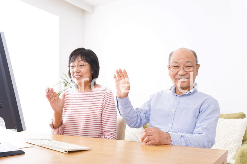 パソコンでテレビ電話をする高齢の夫婦