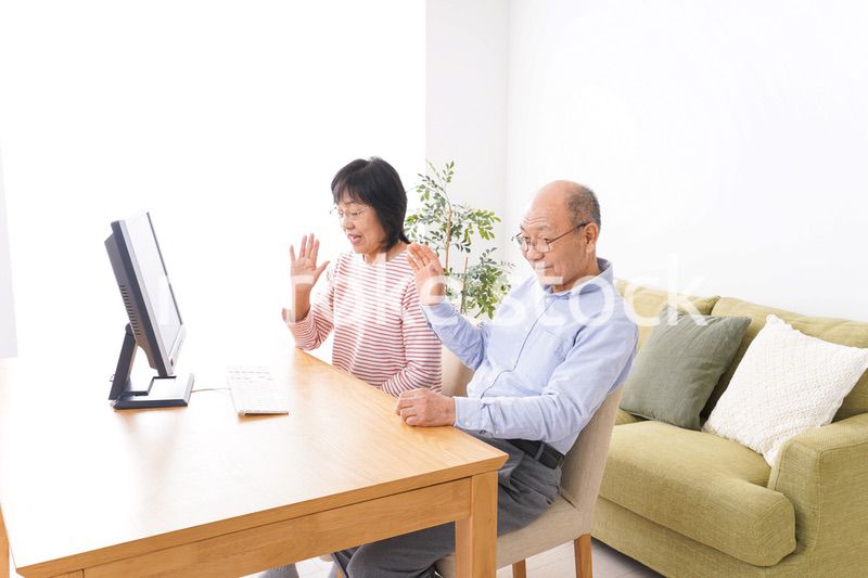 パソコンでテレビ電話をする高齢の夫婦