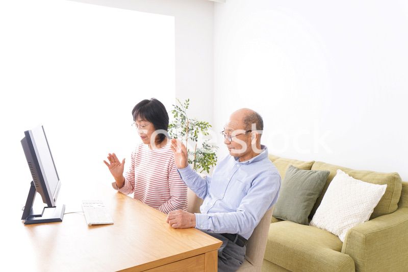 パソコンでテレビ電話をする高齢の夫婦