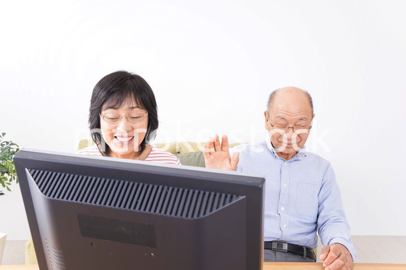 パソコンでテレビ電話をする高齢の夫婦