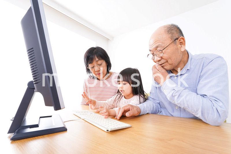 パソコンを使う祖父母と子ども