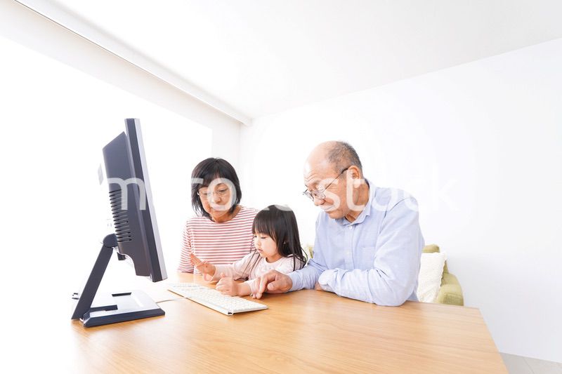 パソコンを使う祖父母と子ども