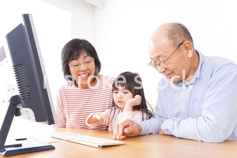 パソコンを使う祖父母と子ども