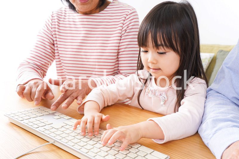 パソコンを使う祖父母と子ども