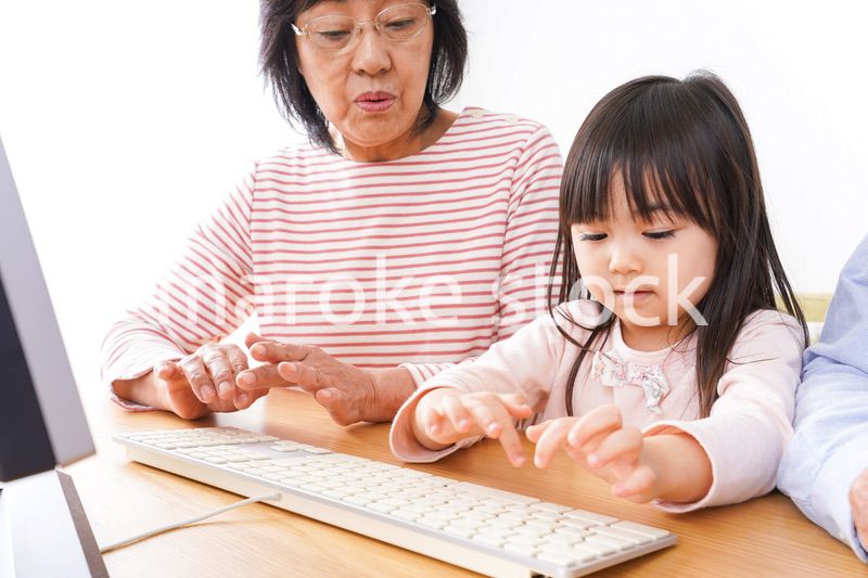 パソコンを使う祖父母と子ども