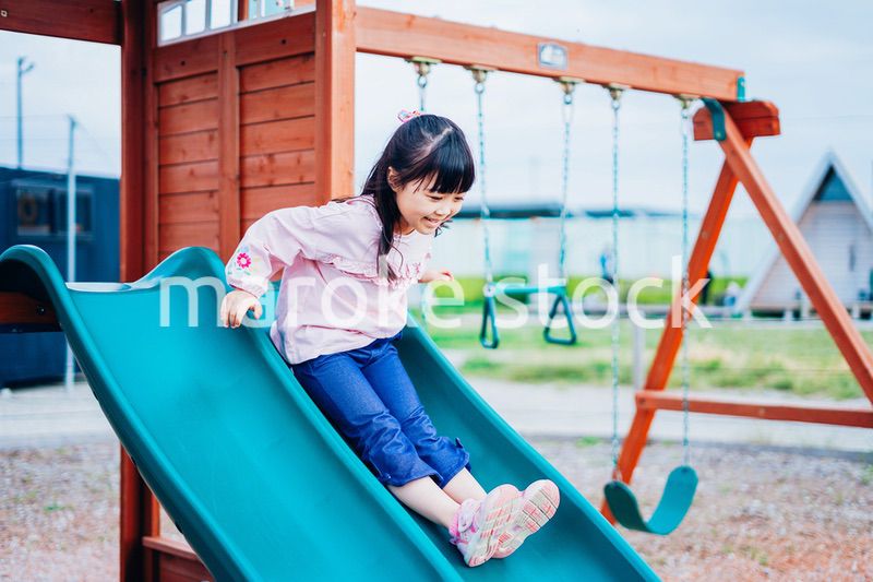 滑り台で遊ぶ小さな女の子