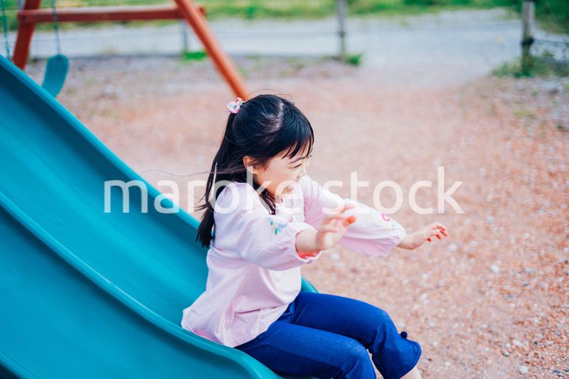 滑り台で遊ぶ小さな女の子