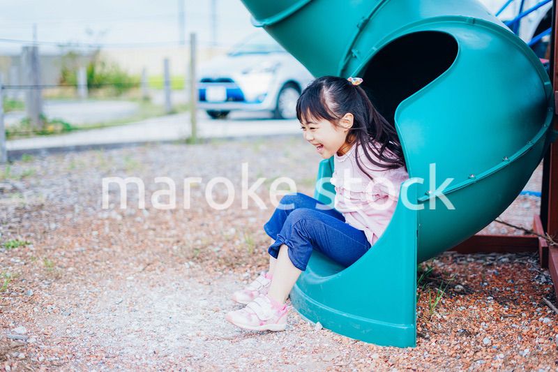 滑り台で遊ぶ小さな女の子
