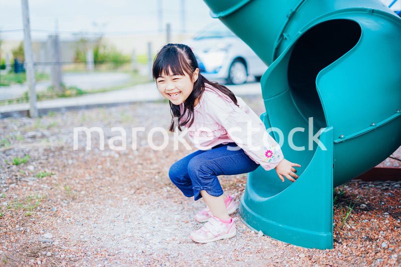 滑り台で遊ぶ小さな女の子