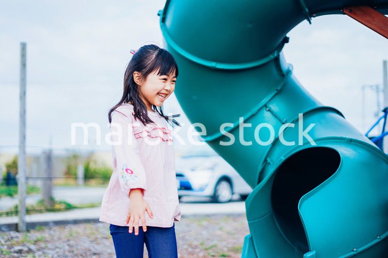 滑り台で遊ぶ小さな女の子