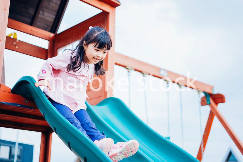 滑り台で遊ぶ小さな女の子