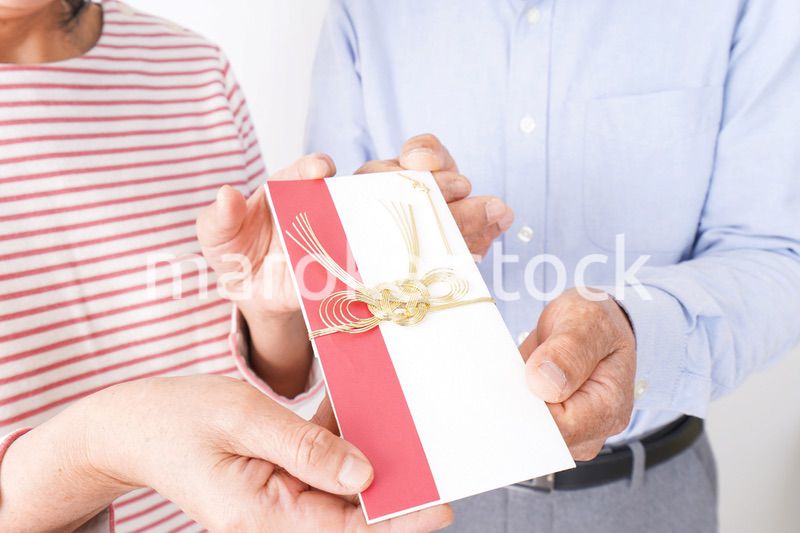 お祝いを渡すシニアの夫婦