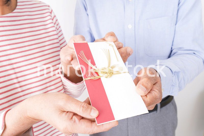 お祝いを渡すシニアの夫婦