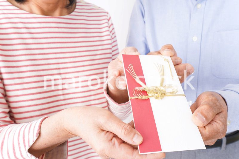 お祝いを渡すシニアの夫婦