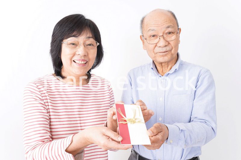お祝いを渡すシニアの夫婦